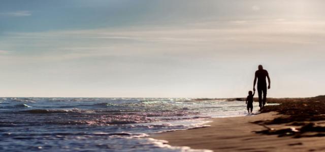 Man and kid walking on the beach